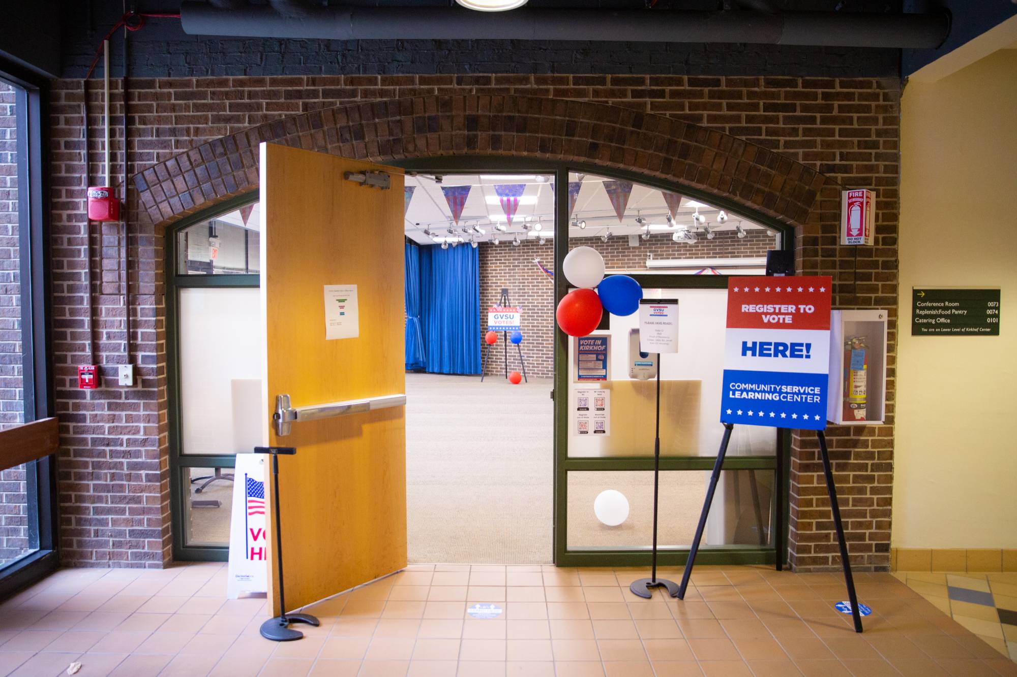 An open door with red, white, and blue, signage and balloons for the Allendale Satellite Clerk's office.